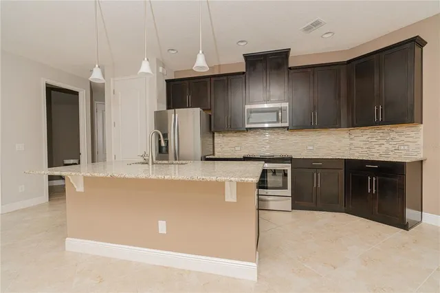 a kitchen with kitchen island granite countertop a stove and a sink