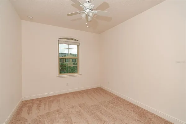 an empty room with a window and a fan
