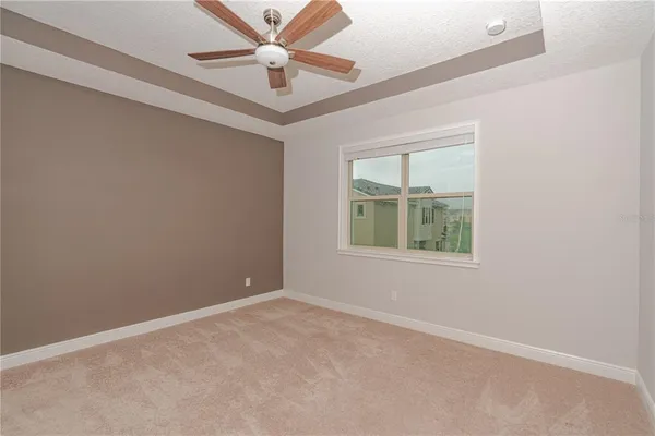 an empty room with windows and fan