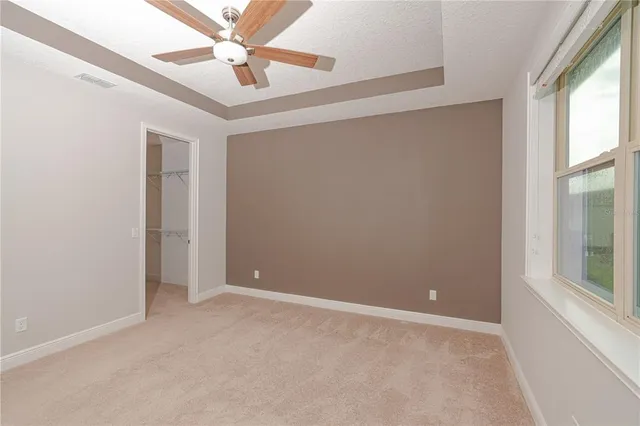 an empty room with a ceiling fan and a fan