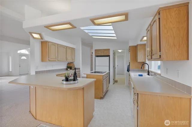 a kitchen with kitchen island a sink a stove and a refrigerator
