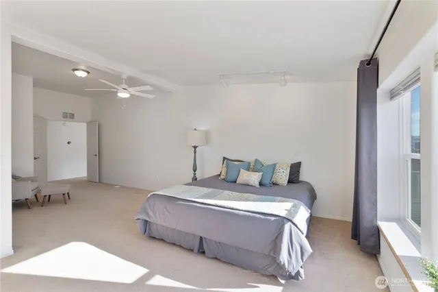 a bathroom with double vanity sinks a large mirror and a bathtub