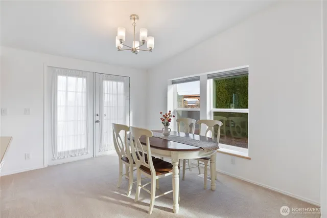 a dining room with furniture a chandelier and window