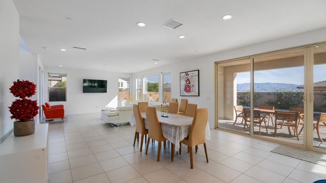 a dining room with furniture and a floor to ceiling window