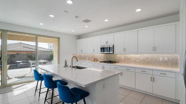 a kitchen with white cabinets stove and sink