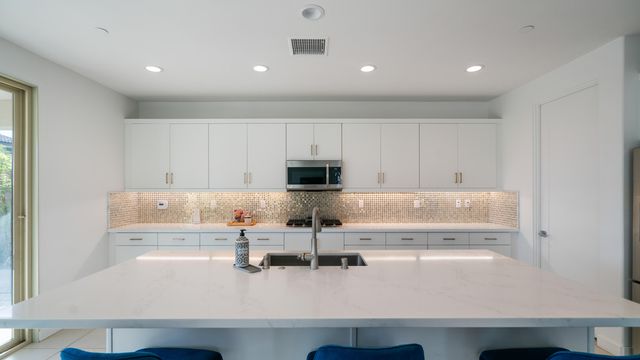 a kitchen with a sink a stove and cabinets