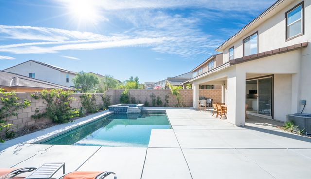 a large white kitchen with stainless steel appliances lots of white furniture