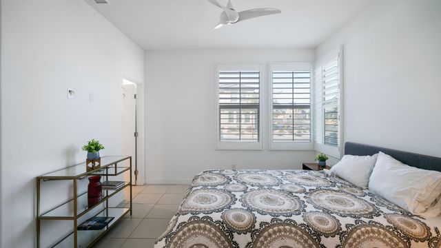 a bedroom with a bed and a potted plant