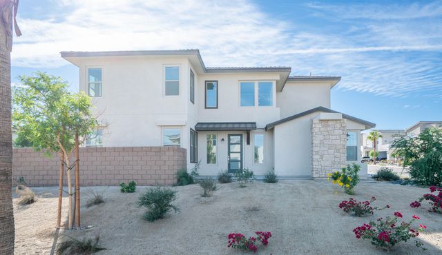 a front view of a house with plants