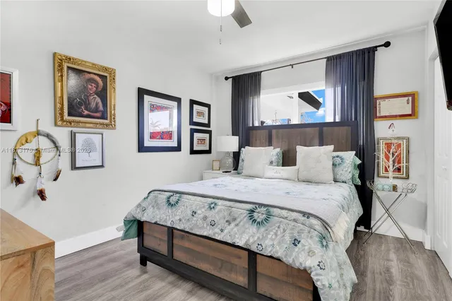 a bedroom with bed and paintings on the wall