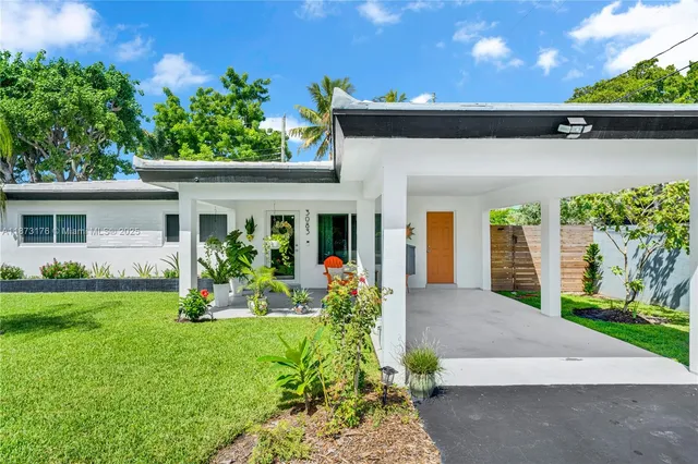 a aerial view of a house with a yard and potted plants