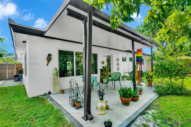 a view of a backyard with table and chairs under an umbrella