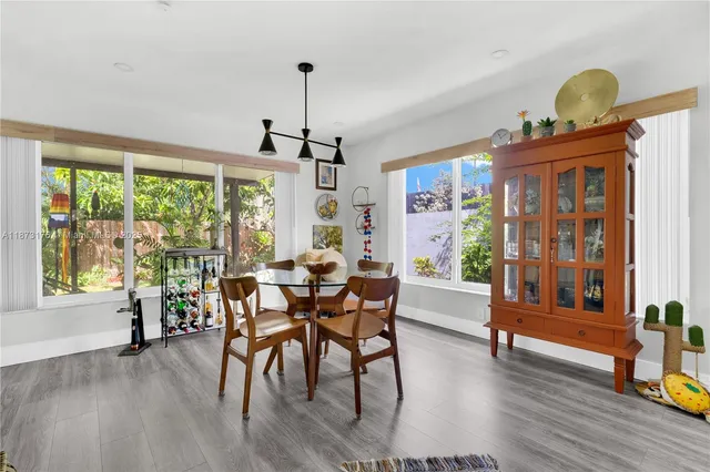 a dining room with furniture a window and wooden floor