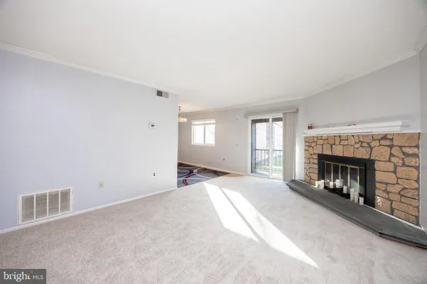 a view of an empty room with a window and fireplace