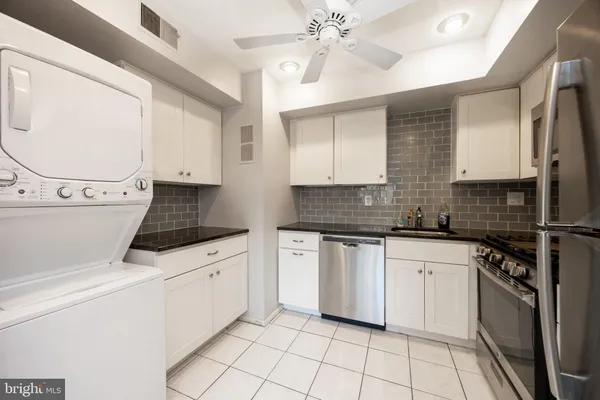 a kitchen with stainless steel appliances granite countertop a stove a sink and a refrigerator
