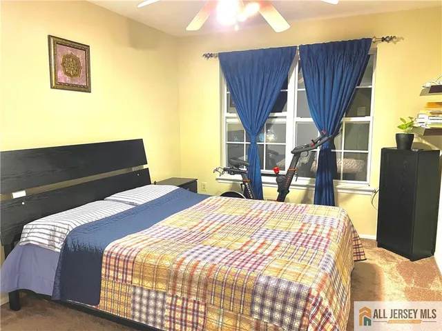 a bedroom with a bed a dresser and a large mirror