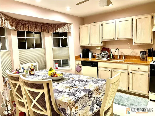 a kitchen with stainless steel appliances kitchen island granite countertop a stove a sink a dining table and chairs