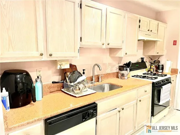 a kitchen with stainless steel appliances granite countertop a stove a sink and white cabinets
