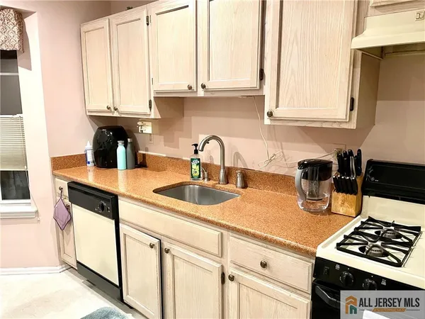 a kitchen with appliances a sink and cabinets