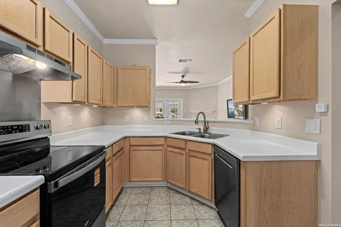 a kitchen with a sink stove top oven and cabinets