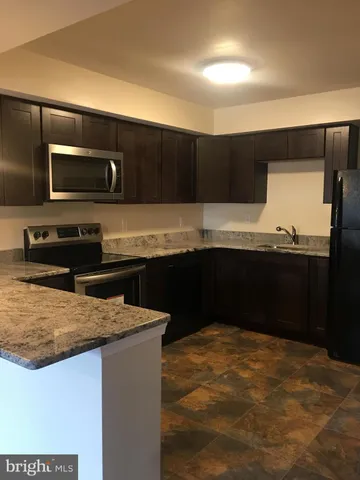 a kitchen with kitchen island sink and refrigerator
