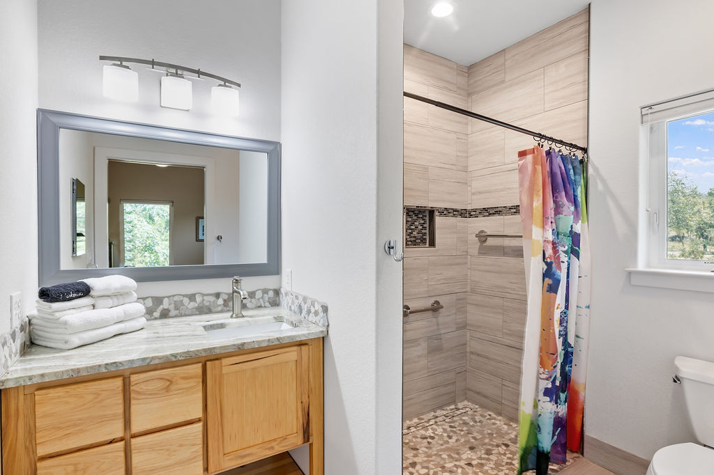 13326 Trautwein Road Austin, TX 78737 - Photo 23 of 38 Bathroom with tiled shower, toilet, and vanity