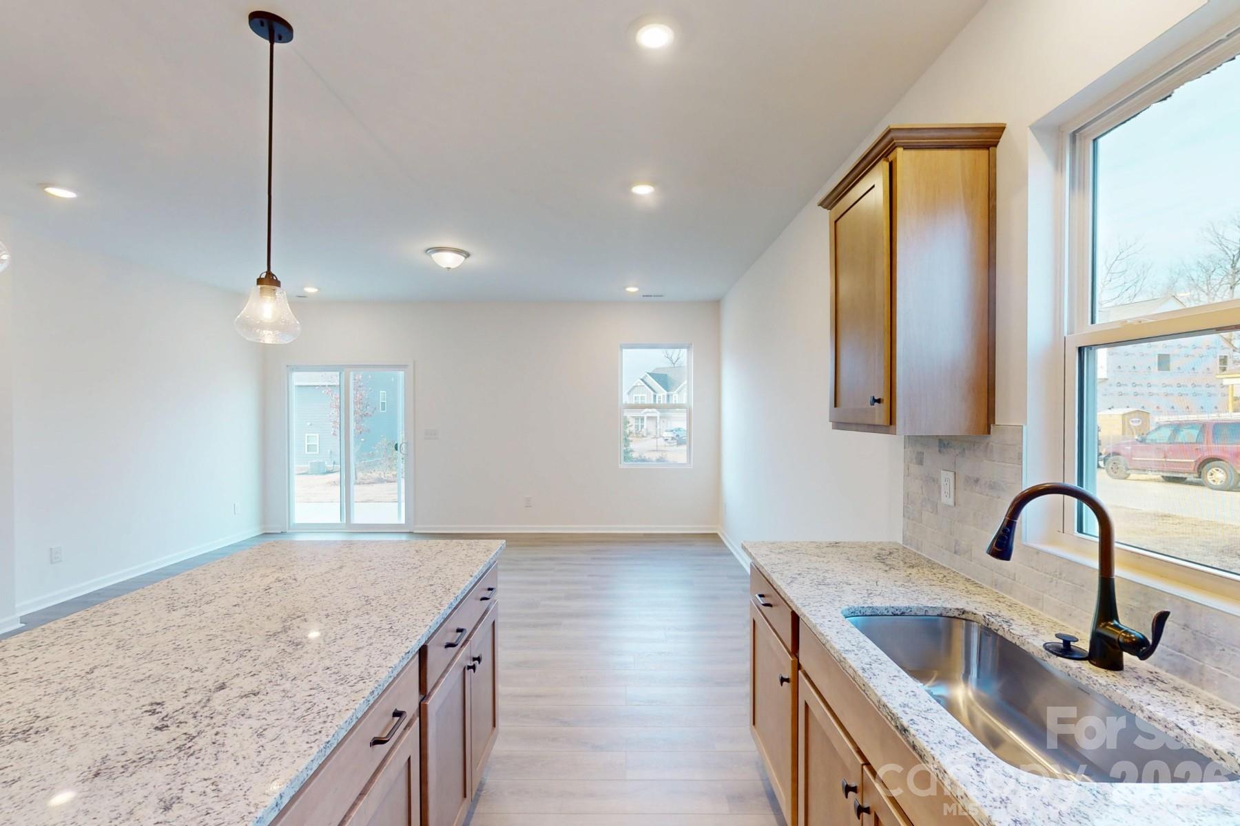 929 Barker Street Monroe, NC 28112 - Photo 11 of 26 a kitchen with granite countertop a sink a counter top space and cabinets