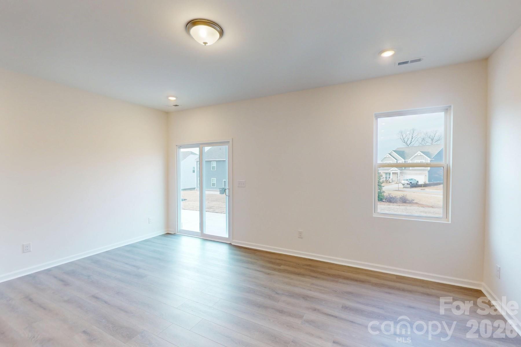 929 Barker Street Monroe, NC 28112 - Photo 13 of 26 an empty room with wooden floor and windows