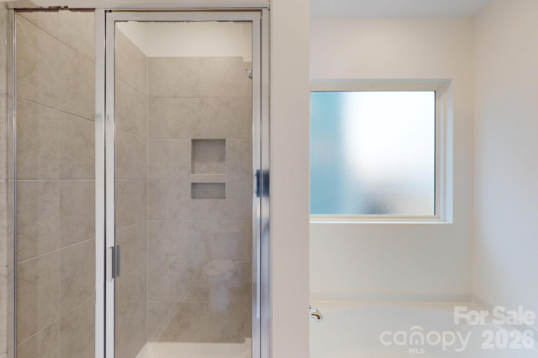 929 Barker Street Monroe, NC 28112 - Photo 25 of 26 a bathroom with a shower and a window