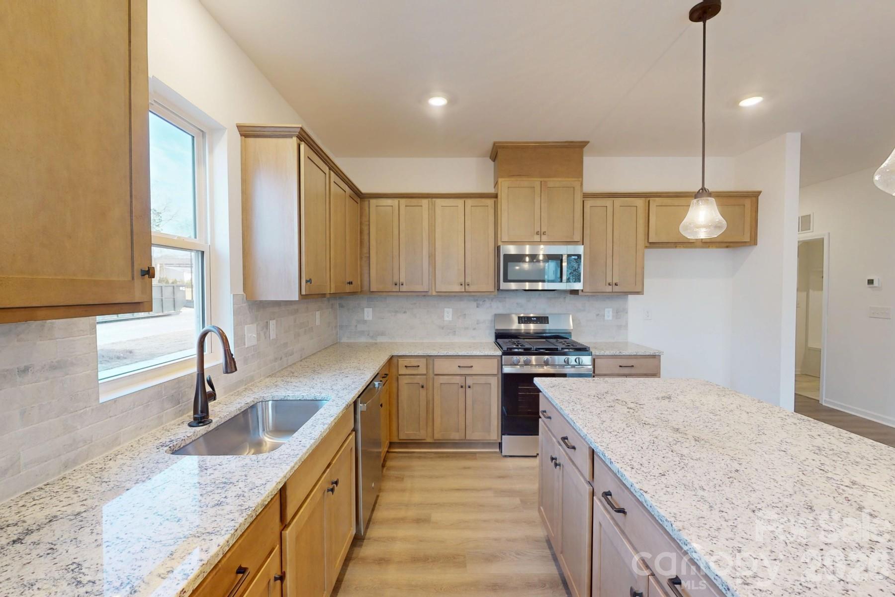 929 Barker Street Monroe, NC 28112 - Photo 6 of 26 a kitchen with a sink stove and cabinets