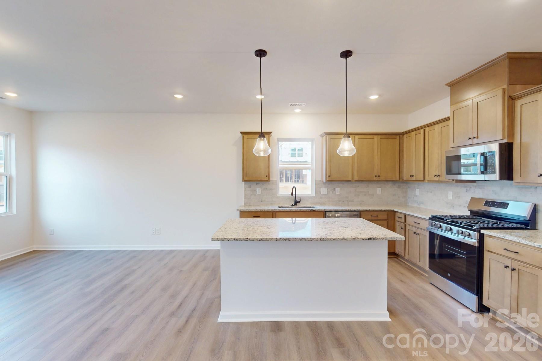 929 Barker Street Monroe, NC 28112 - Photo 7 of 26 a kitchen with stainless steel appliances granite countertop a sink a stove and a wooden floors