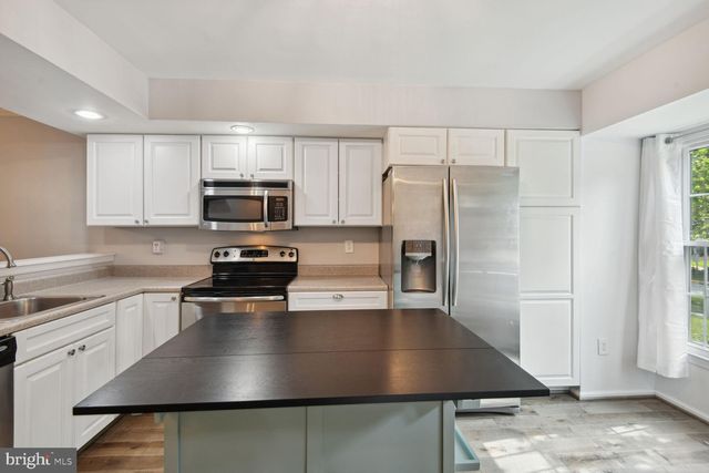 a kitchen with a center island and stainless steel appliances