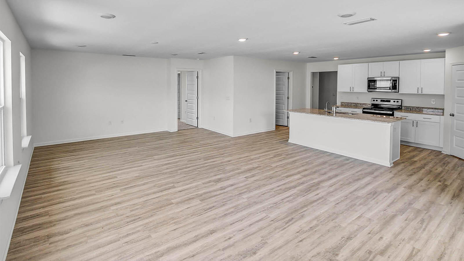 219 Gray Owl Drive Freeport, FL 32439 - Photo 5 of 22 a large kitchen with stainless steel appliances wooden floors and white walls
