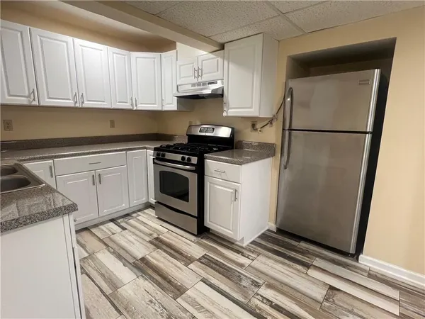 a kitchen with white cabinets and white appliances
