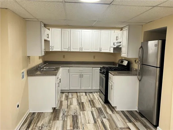 a kitchen with a refrigerator and white cabinets