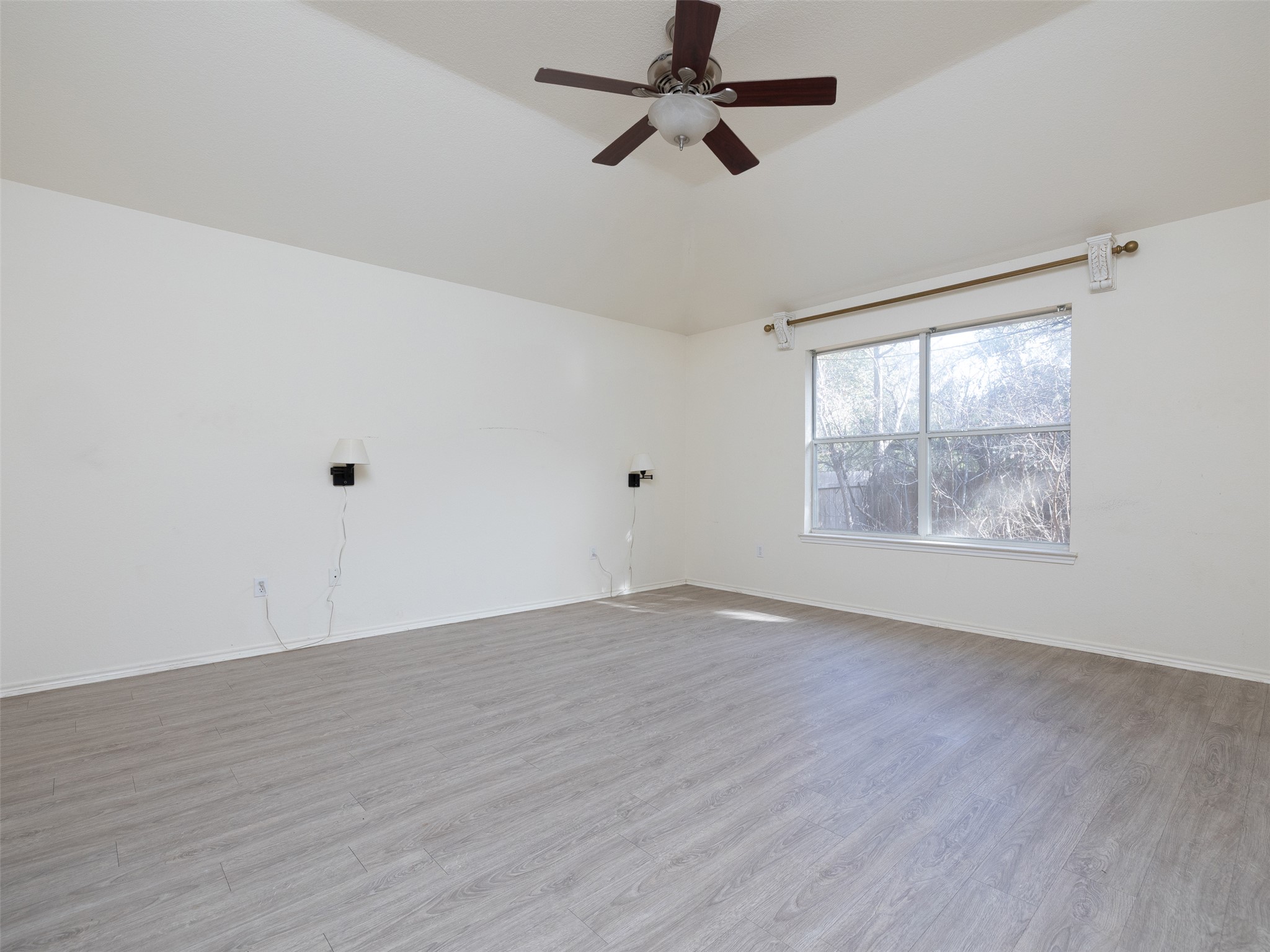 8537 Foxhound Trail Austin, TX 78729 - Photo 16 of 26 Empty room with light wood-style flooring, a ceiling fan, and lofted ceiling