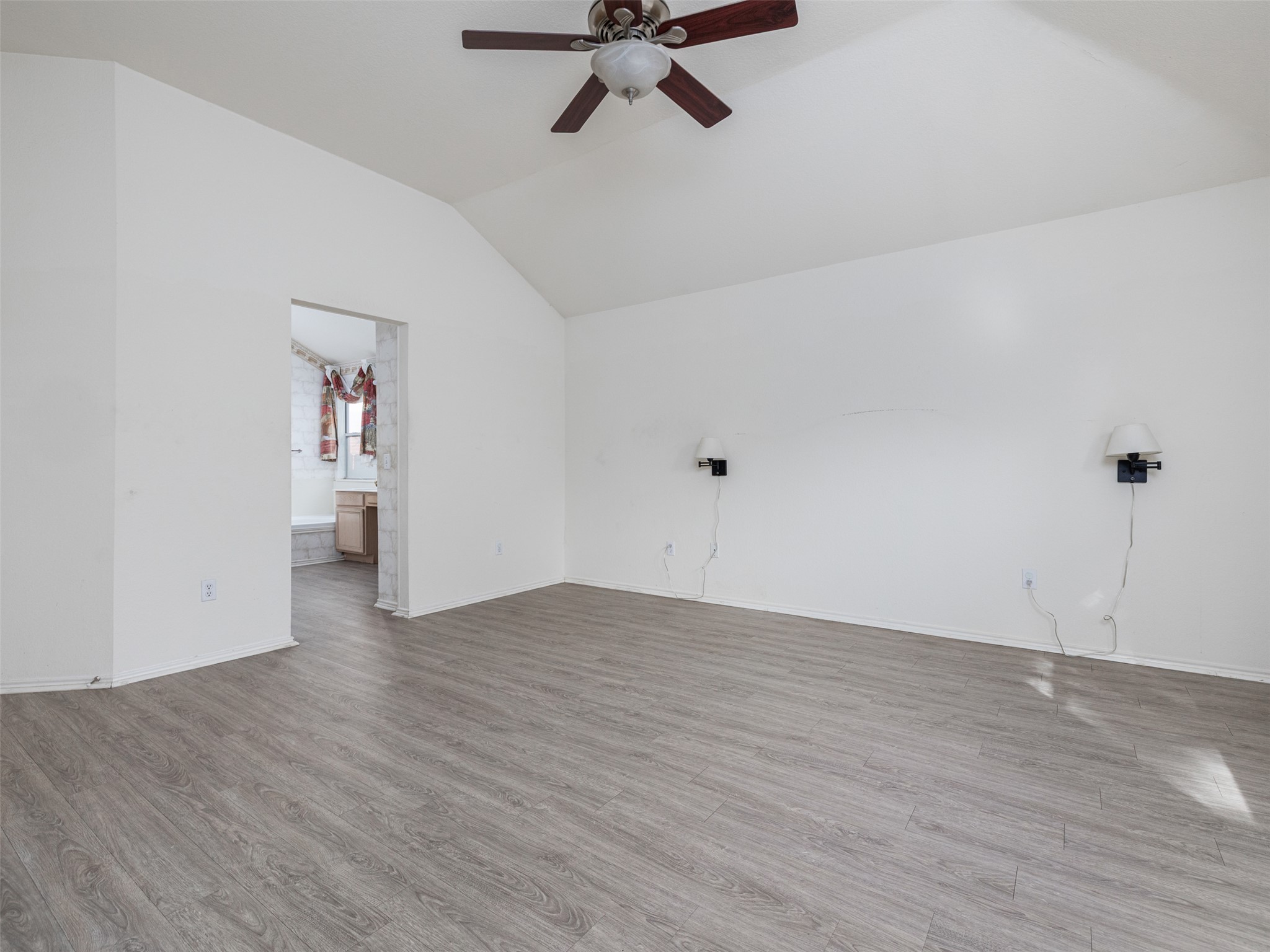 8537 Foxhound Trail Austin, TX 78729 - Photo 17 of 26 Unfurnished room with a ceiling fan, lofted ceiling, and wood finished floors