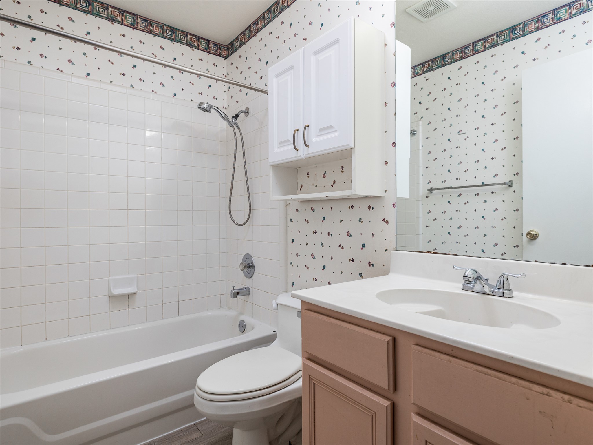 8537 Foxhound Trail Austin, TX 78729 - Photo 20 of 26 Full bathroom featuring wallpapered walls, shower combination, and vanity