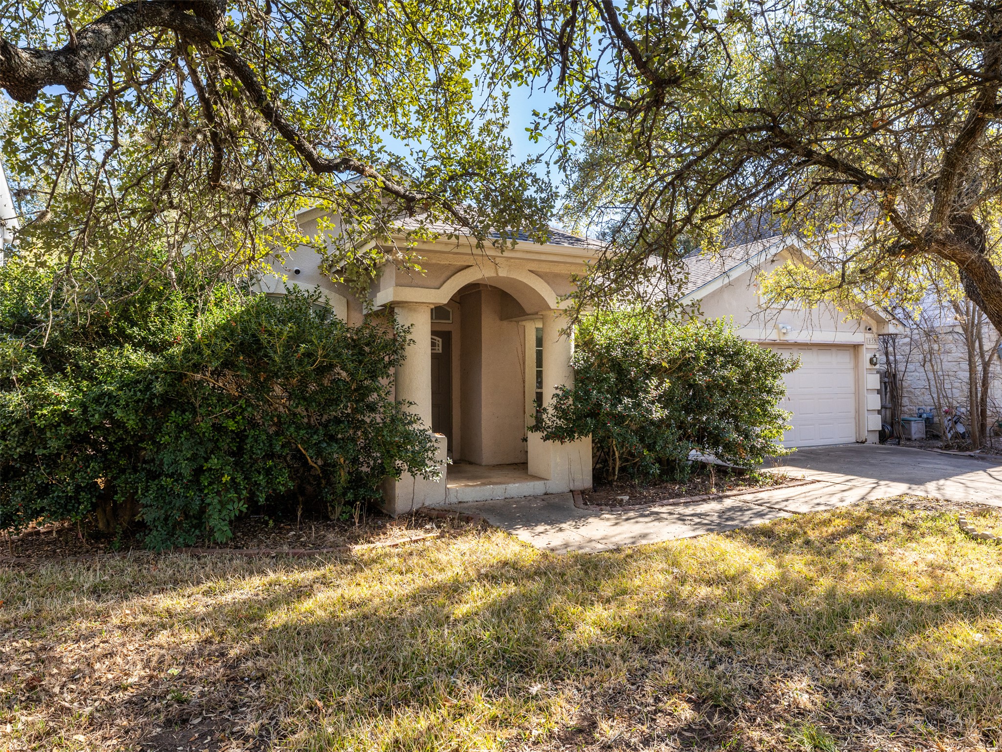 8537 Foxhound Trail Austin, TX 78729 - Photo 2 of 26 View of front of house with driveway, a garage, stucco siding, and a front lawn