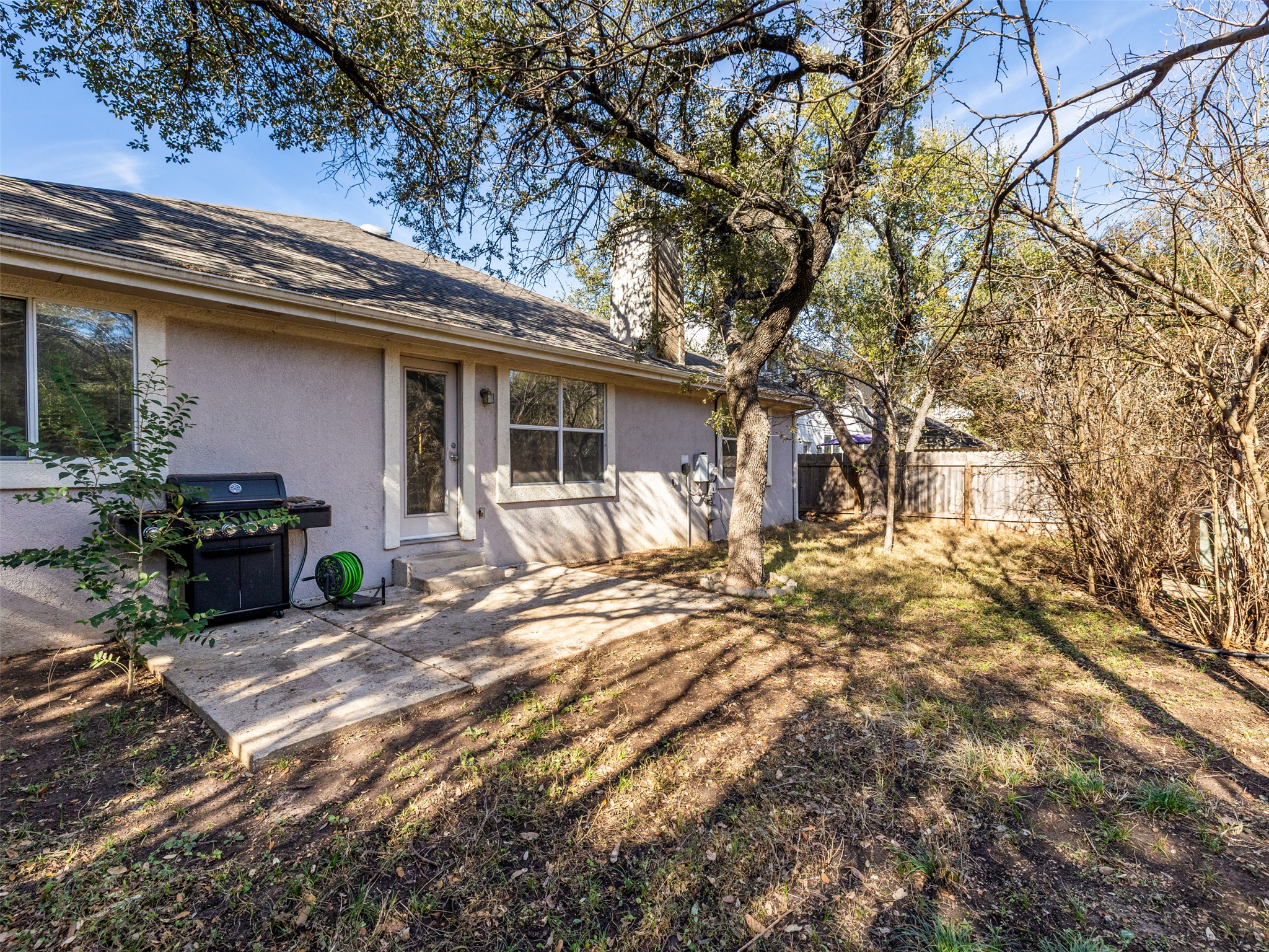 8537 Foxhound Trail Austin, TX 78729 - Photo 24 of 26 Back of house with stucco siding, a patio, and roof with shingles