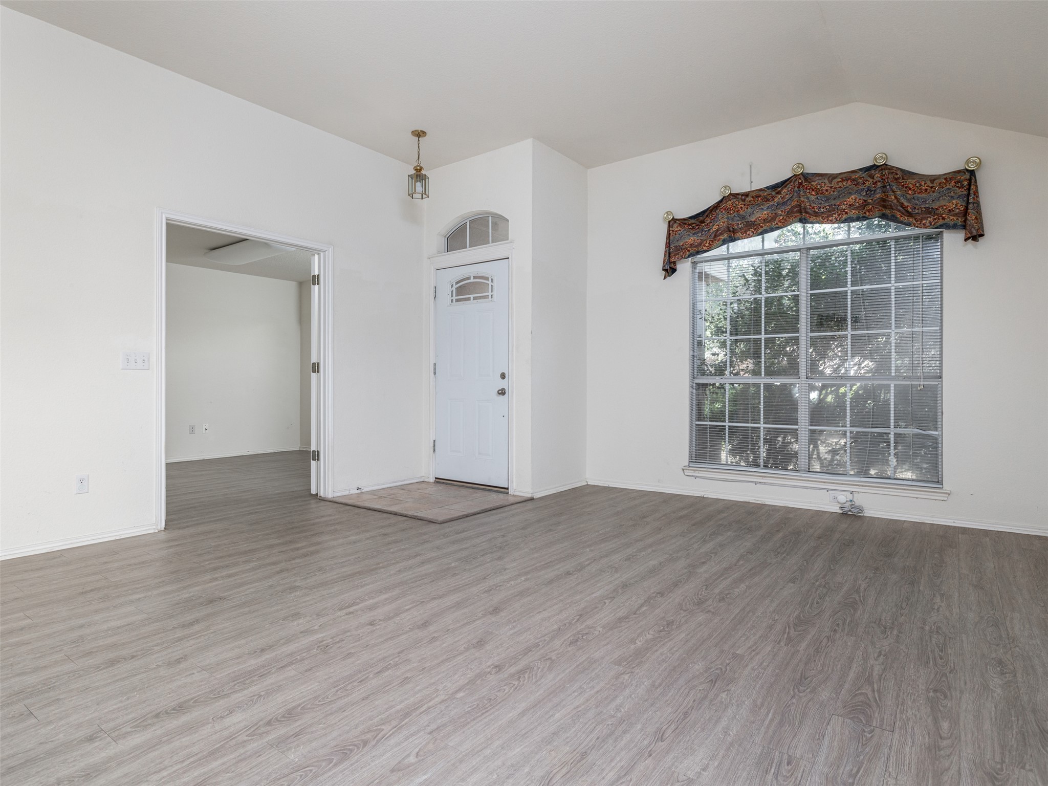 8537 Foxhound Trail Austin, TX 78729 - Photo 5 of 26 Unfurnished room with wood finished floors and vaulted ceiling