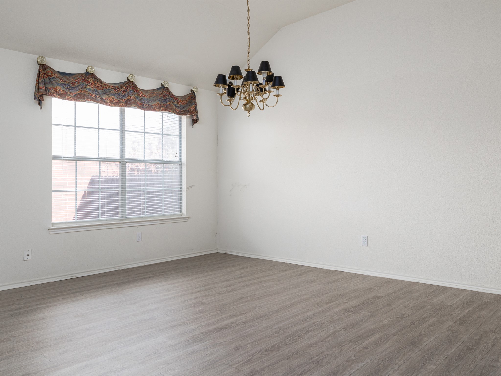 8537 Foxhound Trail Austin, TX 78729 - Photo 8 of 26 Spare room featuring hanging lights, lofted ceiling, and wood finished floors
