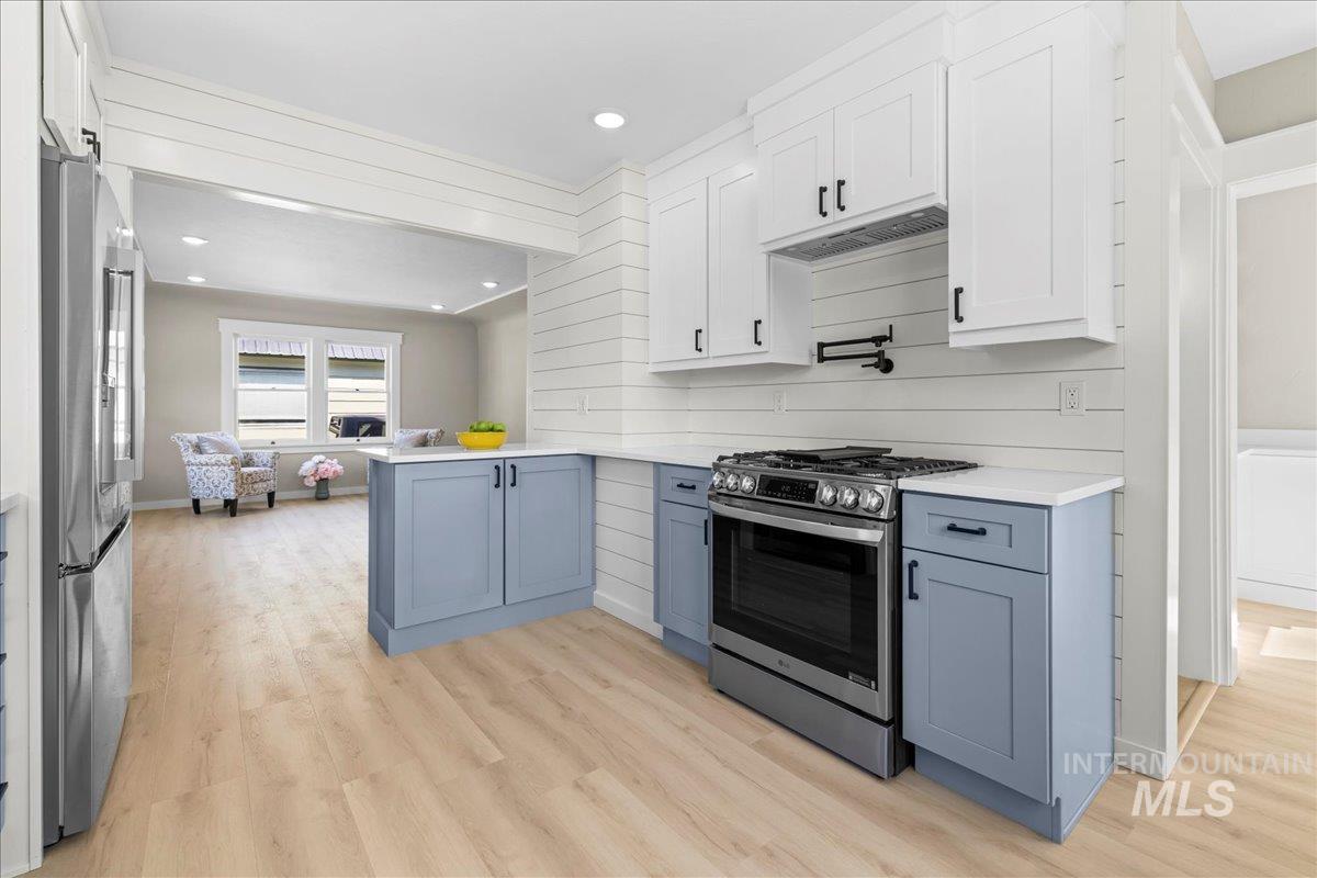 914 West 3rd Street Weiser, ID 83672 - Photo 15 of 49 Kitchen with white cabinetry, appliances with stainless steel finishes, light wood-type flooring, recessed lighting, and gray cabinetry