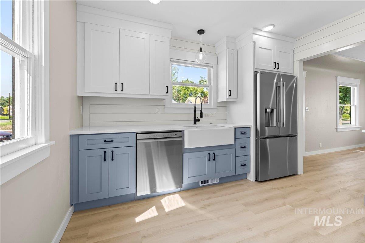 914 West 3rd Street Weiser, ID 83672 - Photo 16 of 49 Kitchen with white cabinets, stainless steel appliances, blue cabinets, hanging light fixtures, and recessed lighting