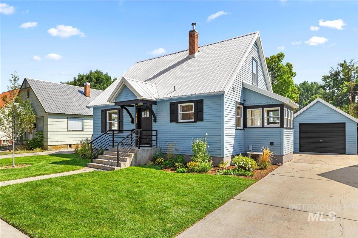 914 West 3rd Street Weiser, ID 83672 - Photo 2 of 49 View of front of house with a garage, an outbuilding, a front yard, and a metal roof