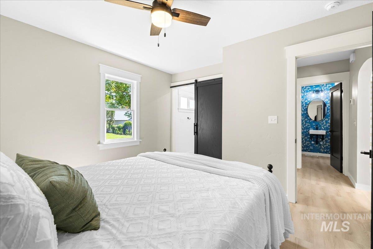 914 West 3rd Street Weiser, ID 83672 - Photo 23 of 49 Bedroom with a barn door, wood finished floors, a ceiling fan, and a closet