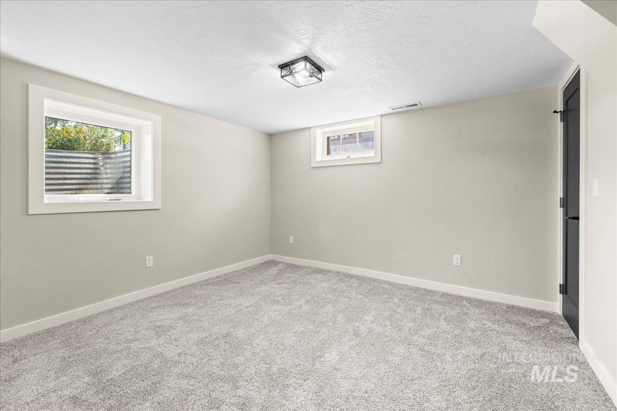 914 West 3rd Street Weiser, ID 83672 - Photo 35 of 49 Below grade area featuring light colored carpet and a textured ceiling
