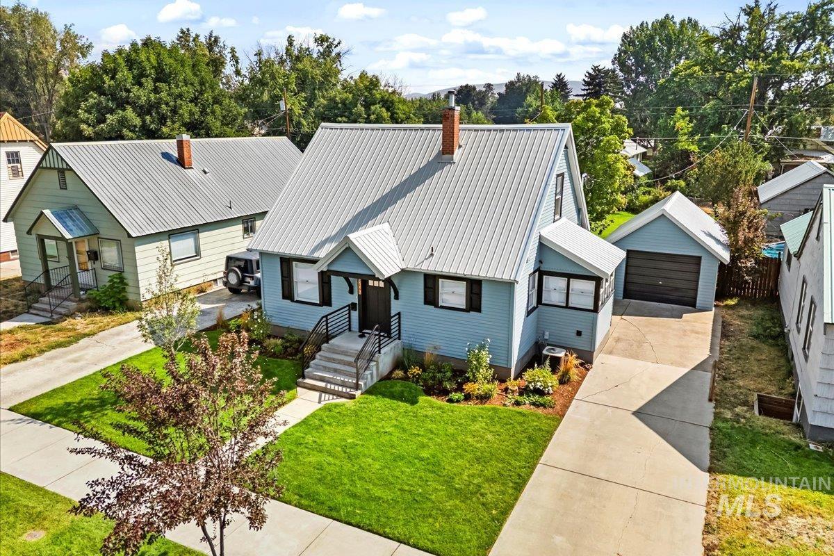 914 West 3rd Street Weiser, ID 83672 - Photo 49 of 49 View of front facade with a detached garage, an outdoor structure, a metal roof, a chimney, and a front yard