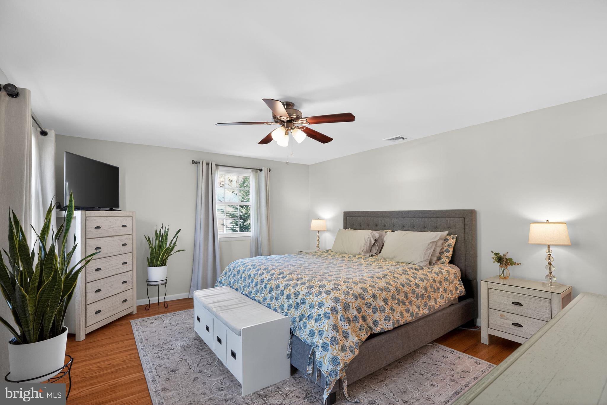 962 Edwards Drive Springfield, PA 19064 - Photo 20 of 32 a bedroom with a bed potted plant on dresser and a chandelier