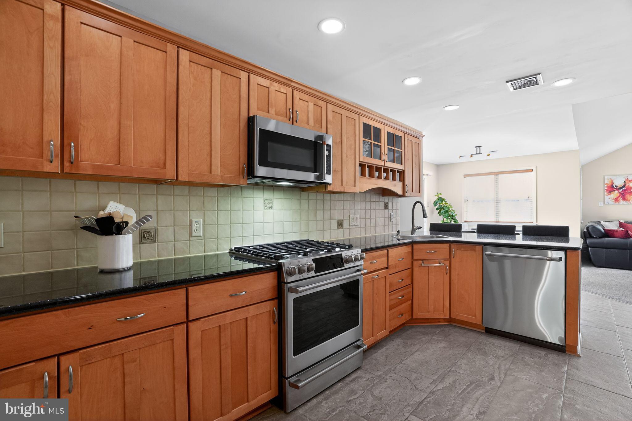 962 Edwards Drive Springfield, PA 19064 - Photo 8 of 32 a kitchen with stainless steel appliances granite countertop a sink stove and microwave